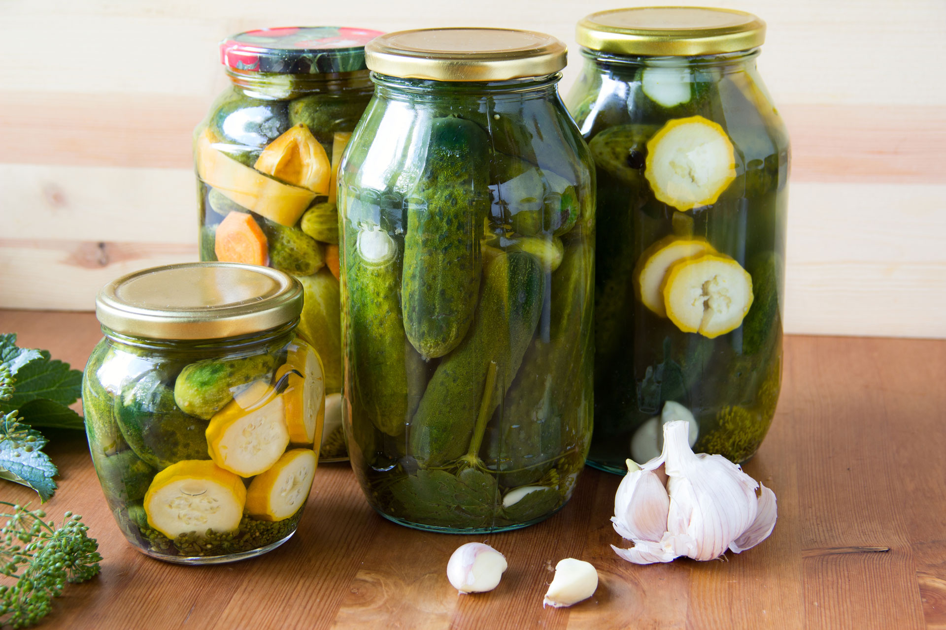 Preserved cucumbers and other vegetables in glass jars.