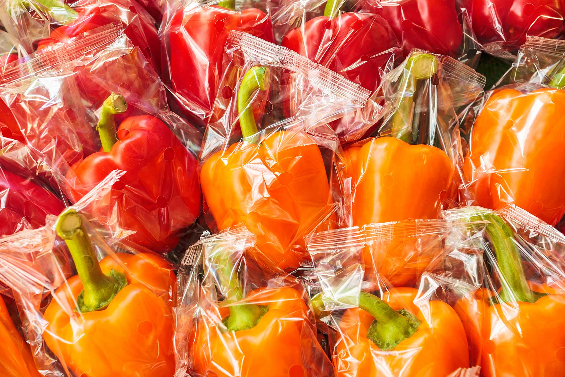 individual bell peppers in plastic food packaging