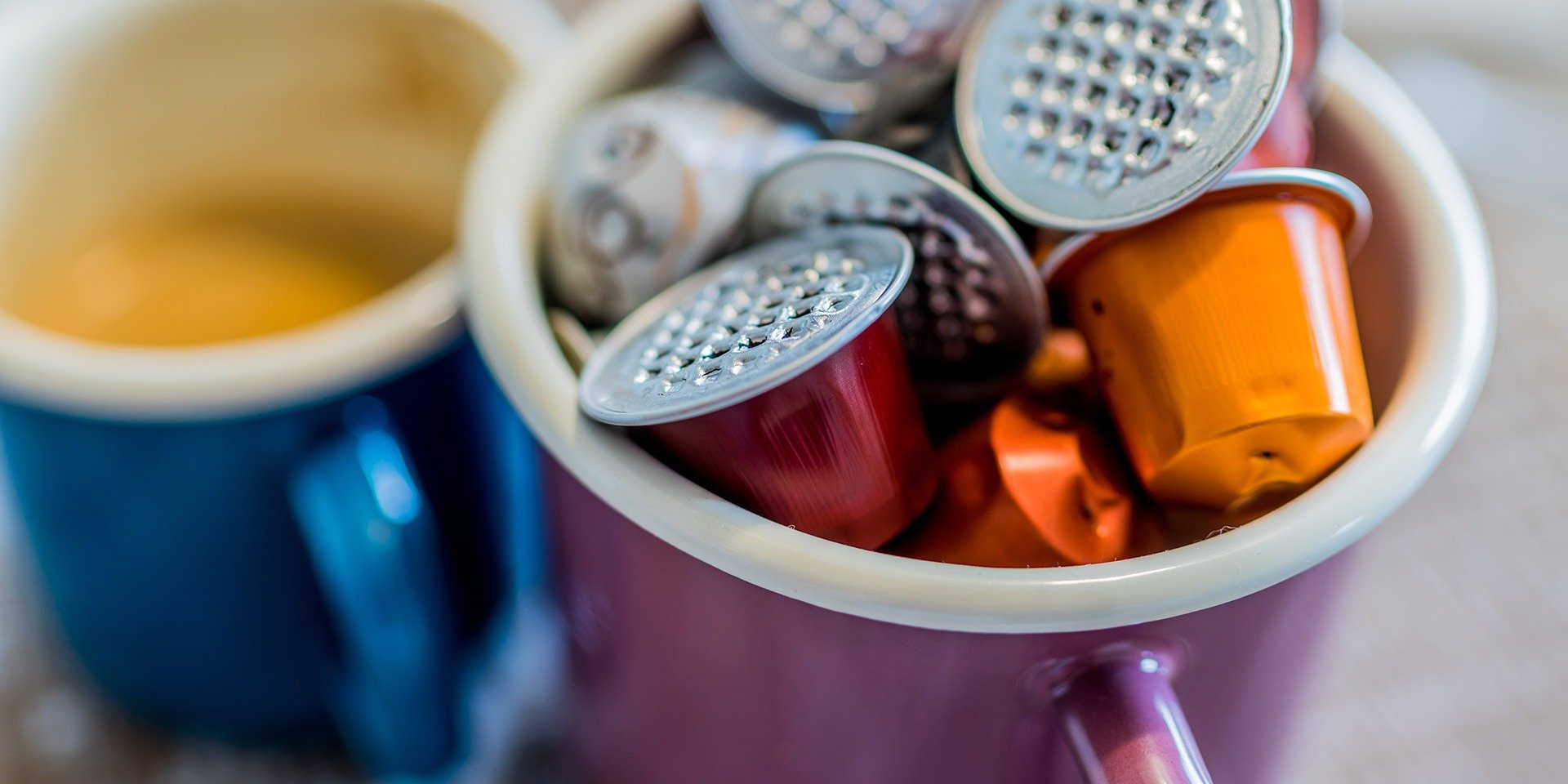 nespresso coffee pods next to a cup of coffee