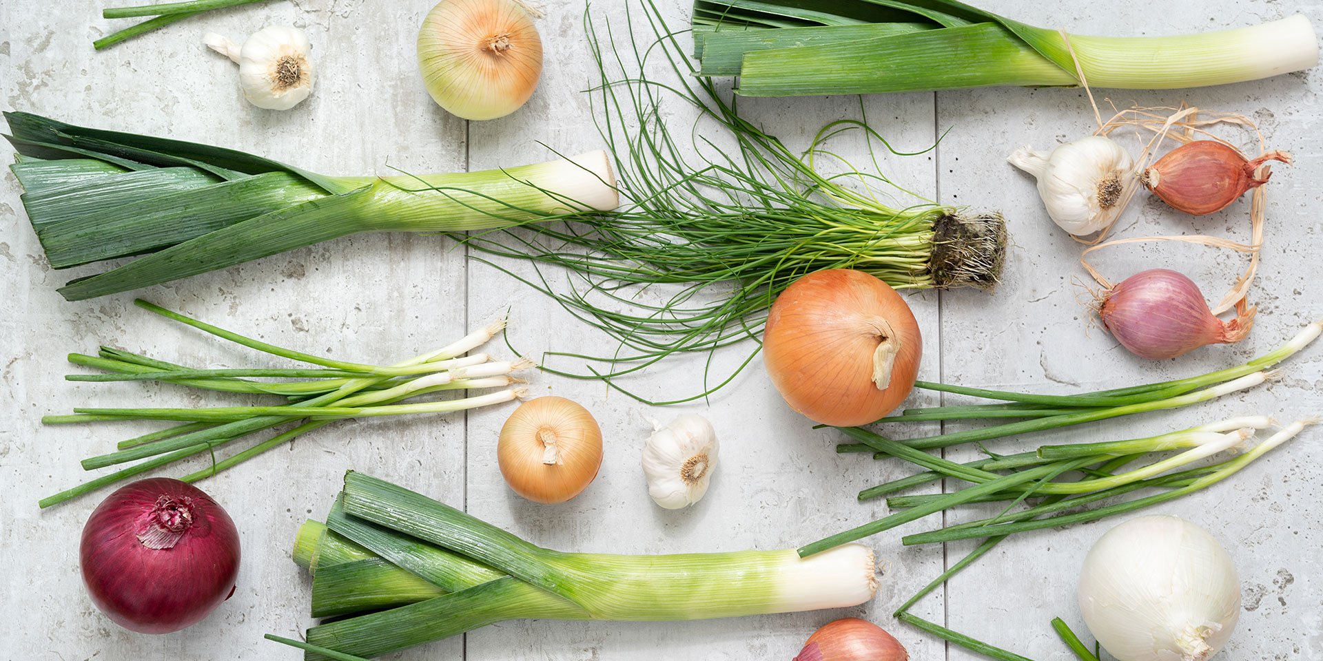assortment of alliums including onions, scallions and leeks