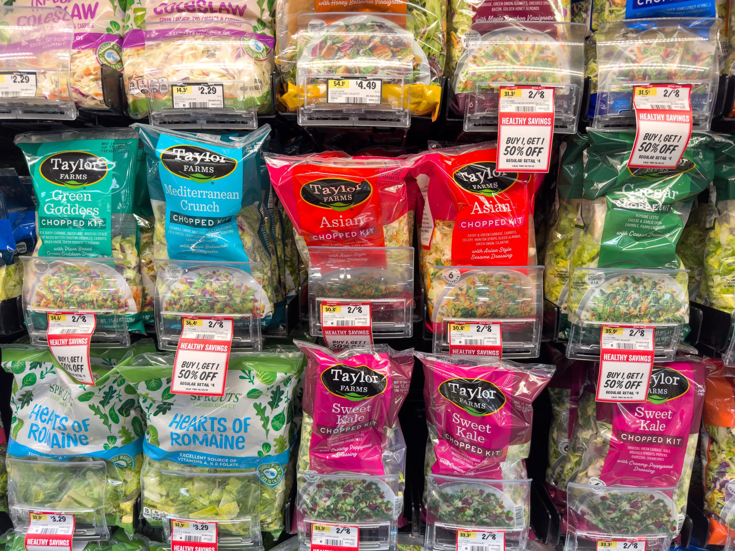 grocery store shelves with Taylor Farms bagged lettuce and lettuce kits